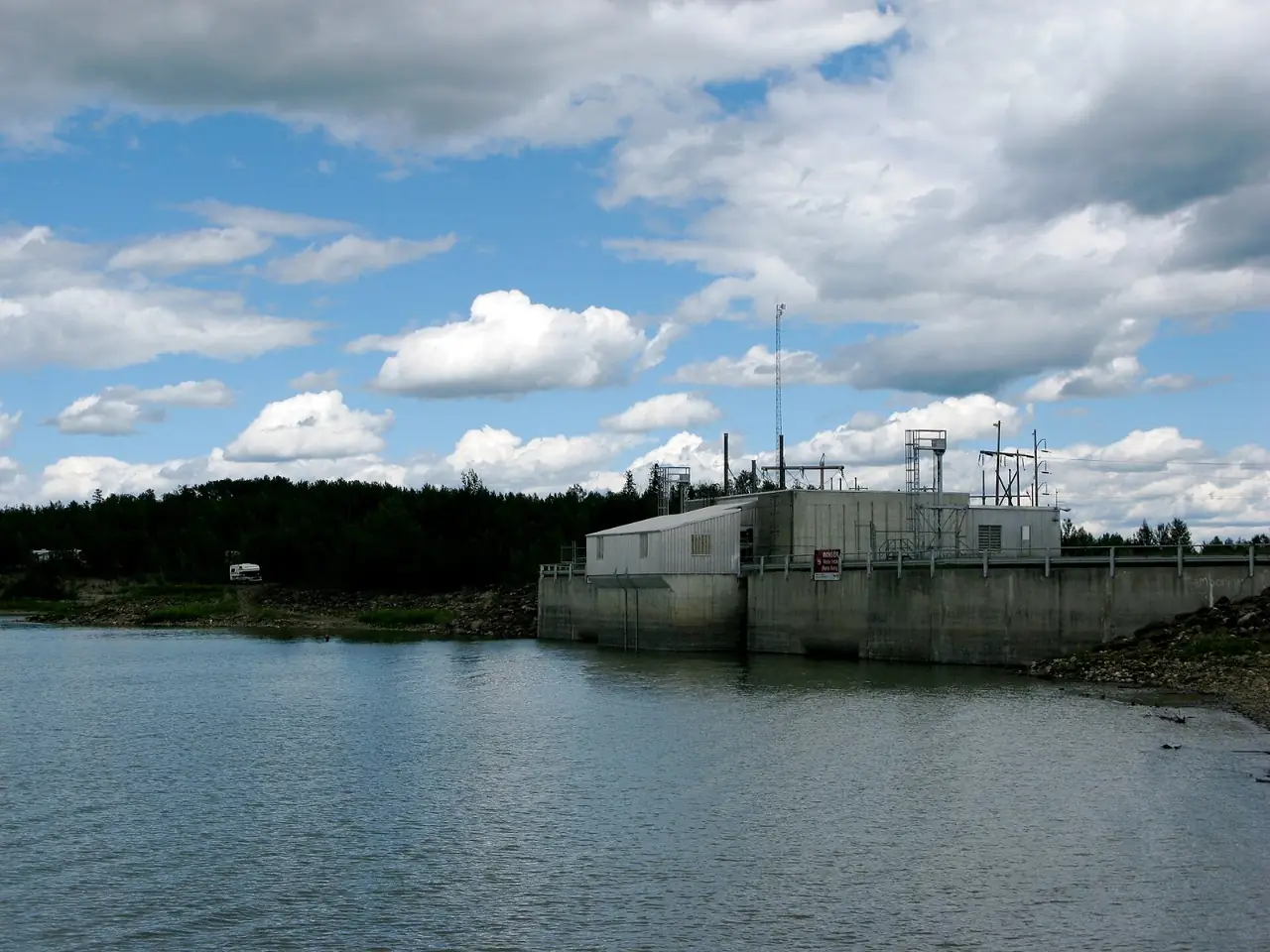 The Brazeau Reservoir under a cloudy sky, with the dam buildings on the far shore