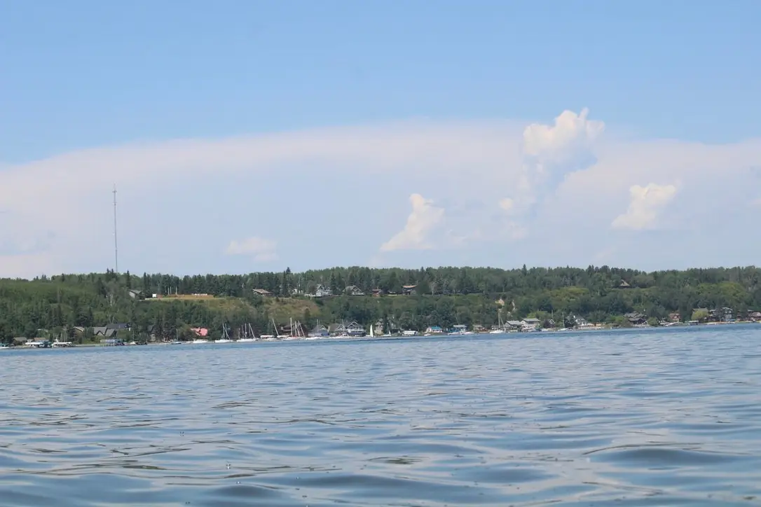 Seba Beach seen from the water of Wabamun Lake, with cabins along the tree-lined shore